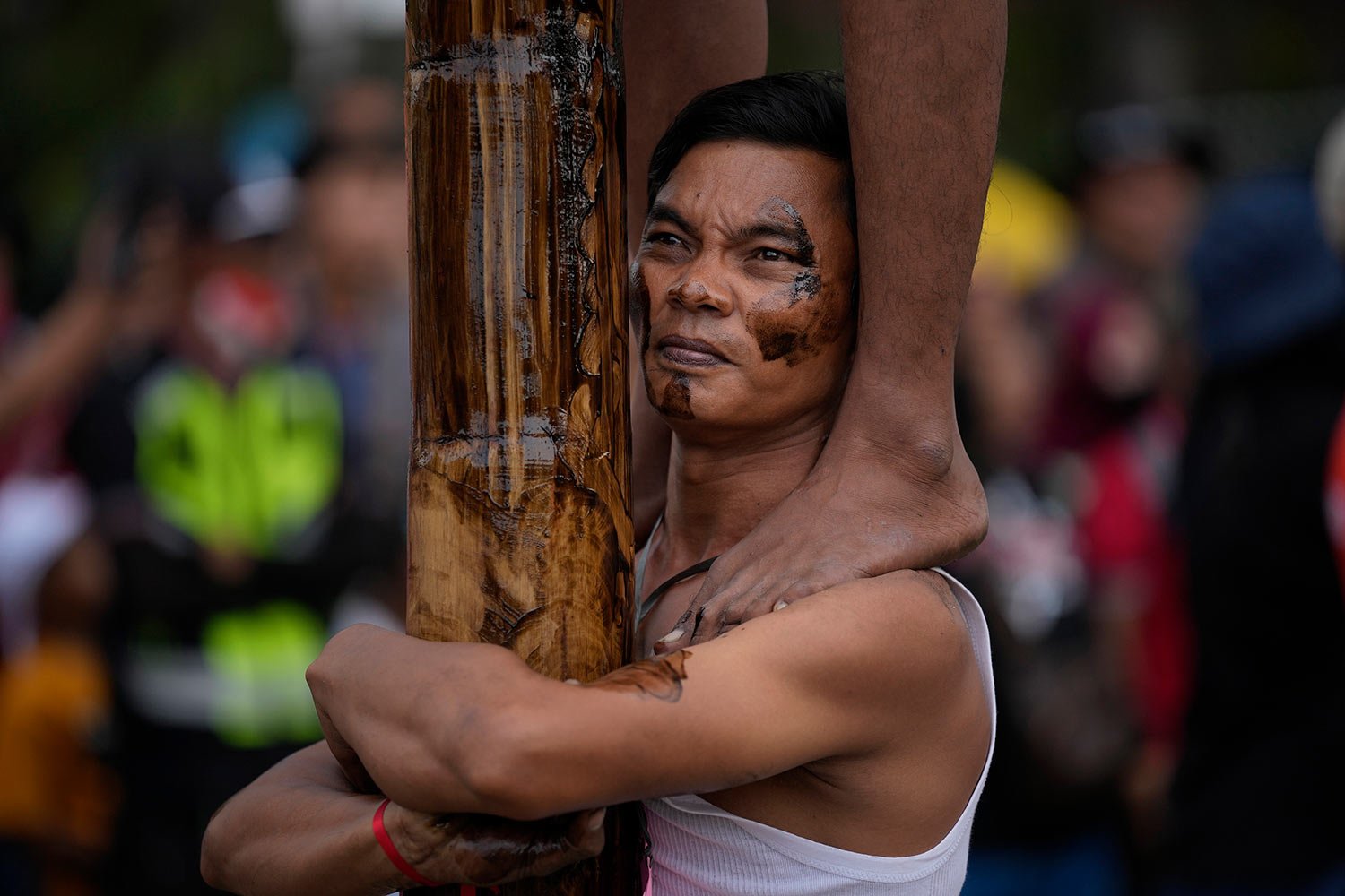  A participant bears the weight of other men above him as people climb greased poles to retrieve prizes during a greased-pole climbing competition held as a part of Independence Day celebrations at Ancol Beach in Jakarta, Indonesia Wednesday, Aug. 17