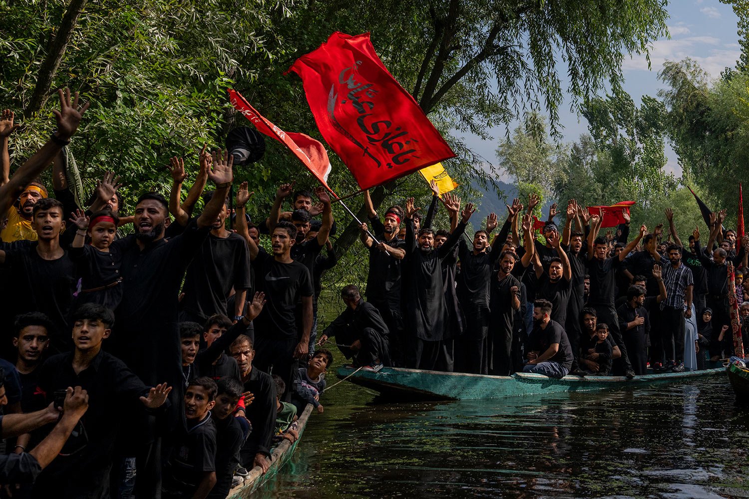  Kashmiri Shiite Muslims shout religious slogans as they participate in a Muharram procession on wooden boats in the interiors of Dal lake, outskirts of Srinagar, Indian controlled Kashmir, Monday, Aug. 8, 2022.  (AP Photo/ Dar Yasin) 