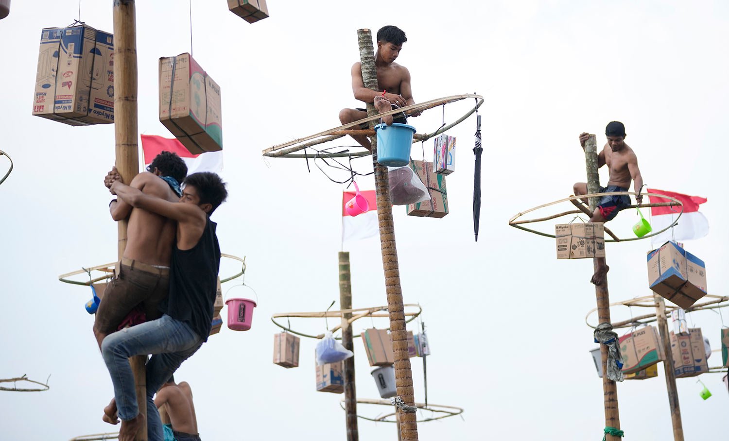  Participants retrieve prizes after climbing up a greased pole during a greased-pole climbing competition held as a part of Independence Day celebrations at Ancol Beach in Jakarta, Indonesia Wednesday, Aug. 17, 2022.  (AP Photo/Tatan Syuflana) 