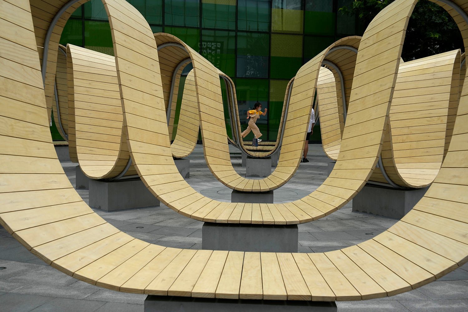  A child wearing a mask runs through an art installation at a mall in Beijing, Friday, Aug. 26, 2022. (AP Photo/Ng Han Guan) 