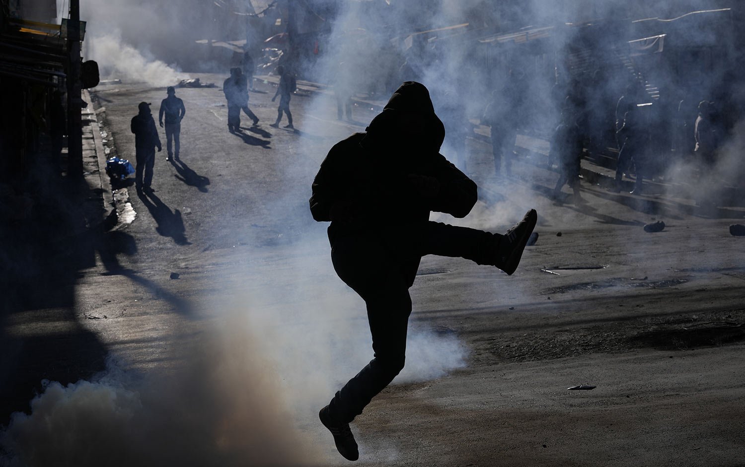  A coca farmer kicks a tear gas canister back at police on the third day of clashes near a coca market in La Paz, Bolivia, Wednesday, Aug. 3, 2022. Anti-government coca farmers are protesting against a new, parallel coca leaf market. (AP Photo/Juan K