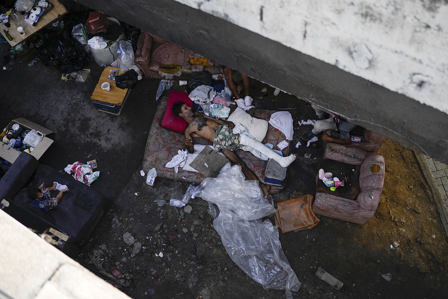  Homeless and injured, Cesar Ramirez lies on a mattress under a bridge in Caracas, Venezuela, Saturday, Aug. 20, 2022. Ramirez, who works informally keeping watch over people's cars, accidentally fell off the bridge while under the influence of alcoh