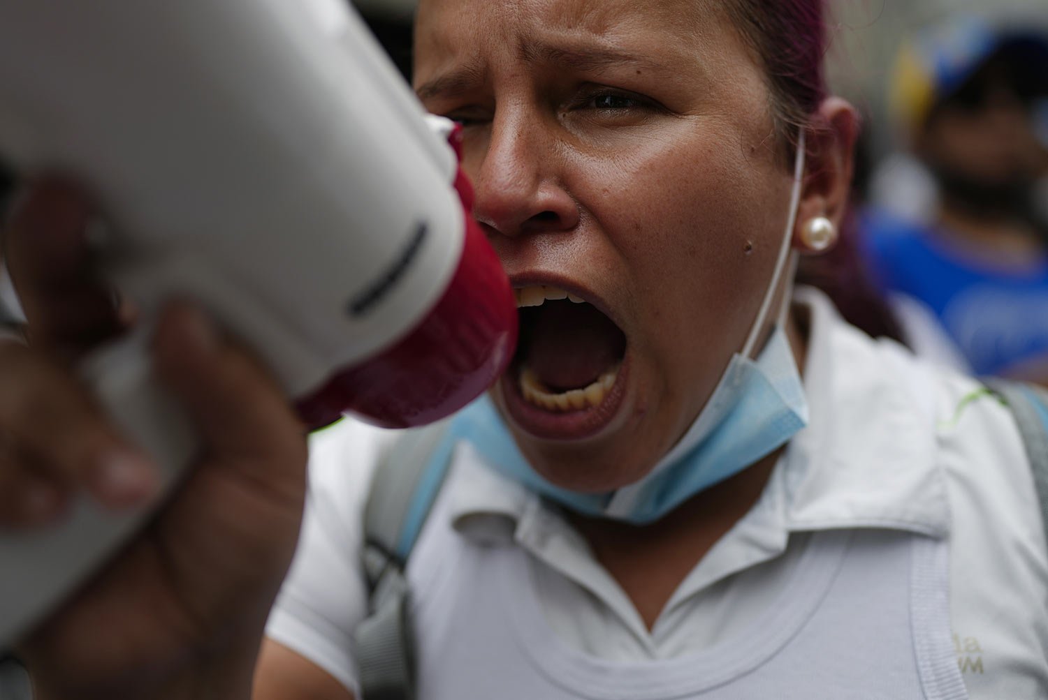  A nurse uses a megaphone during a protest by active and retired public workers demanding the government pay their full benefits and respect collective bargaining agreements, in Caracas, Venezuela, Tuesday, Aug. 23, 2022. (AP Photo/Ariana Cubillos) 