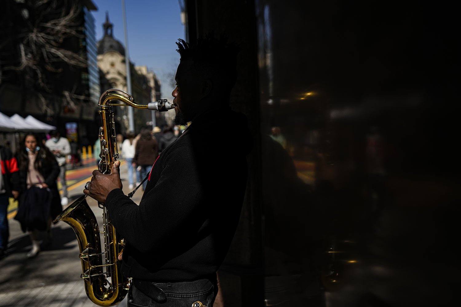  Haitian migrant Philippe Sax, plays his saxophone for alms in downtown Santiago, Chile, Friday, Aug. 19, 2022. (AP Photo/Esteban Felix) 