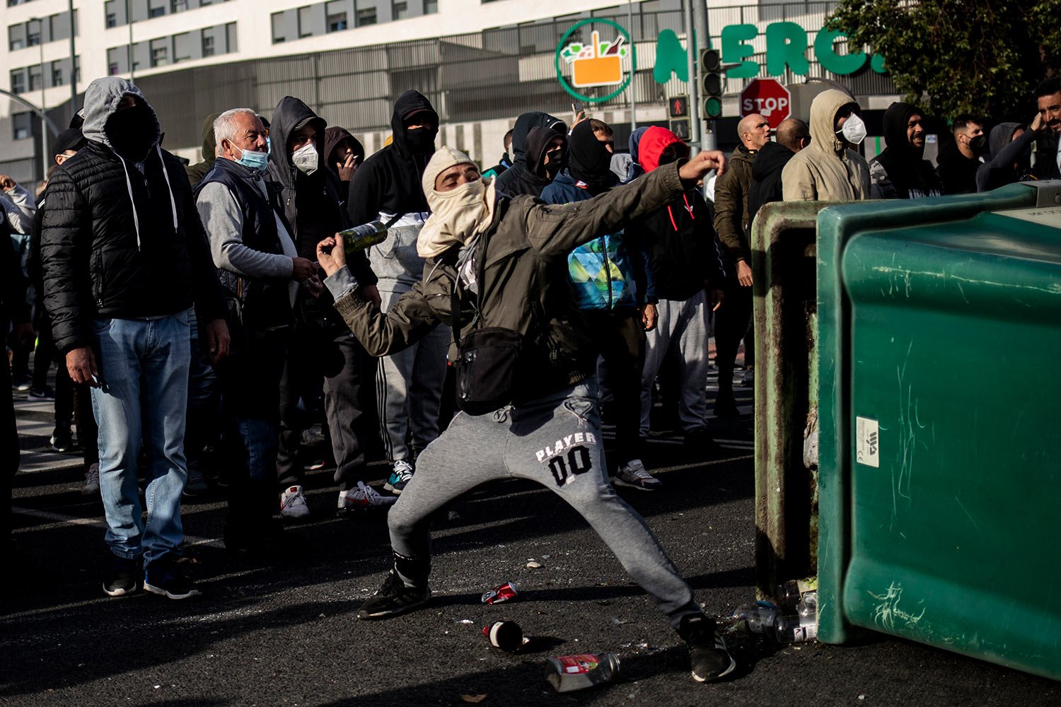  A metal worker throws a bottle during confrontations with the police in Cadiz, southern Spain, Nov. 19, 2021. (AP Photo/Javier Fergo) 