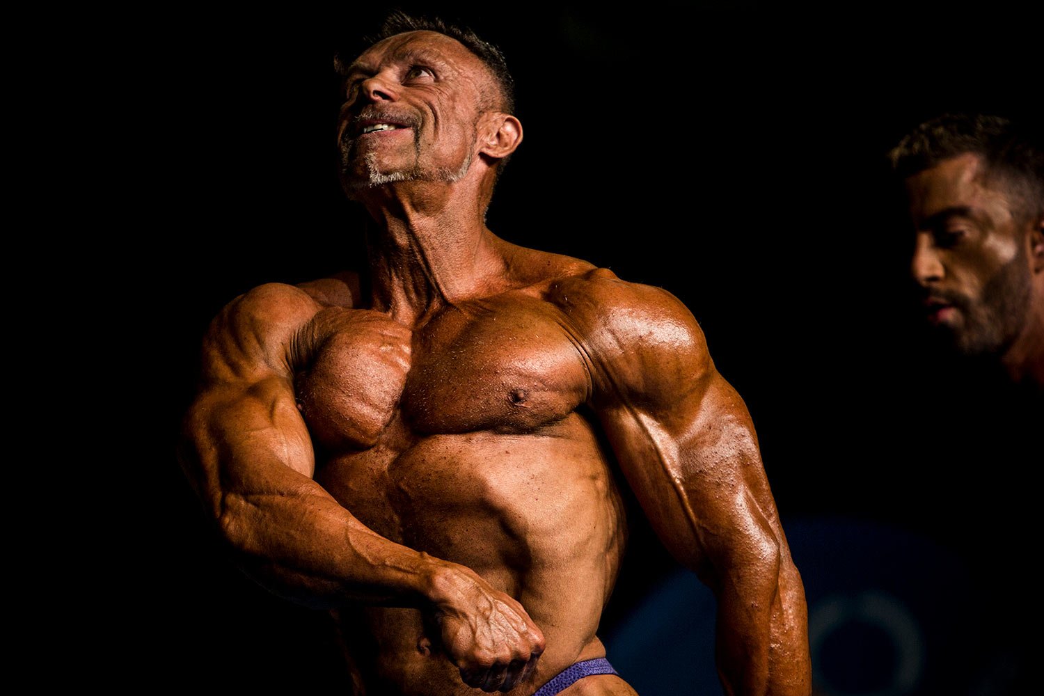  In this Nov. 9, 2019 photo, a contestant poses for judges on stage during the 51st national body building competition held in Estepona, Spain. Spanish absolute championship is the largest yearly event on the national body-building calendar, where ov