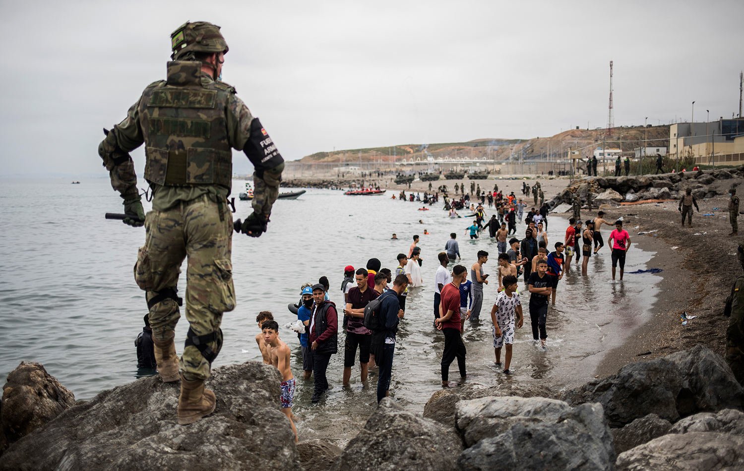  People mainly from Morocco stand on the shore as Spanish Army cordon off the area at the border of Morocco and Spain, at the Spanish enclave of Ceuta, May 18, 2021. (AP Photo/Javier Fergo) 