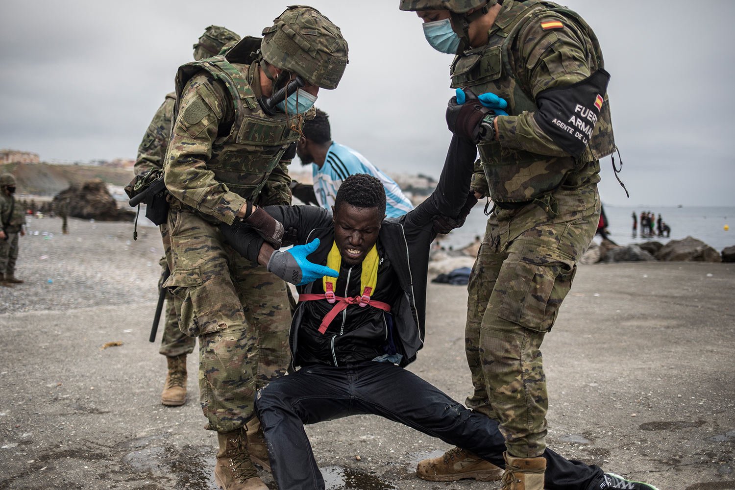  A man is held by soldiers of the Spanish Army at the border of Morocco and Spain, at the Spanish enclave of Ceuta, May 18, 2021. (AP Photo/Javier Fergo) 