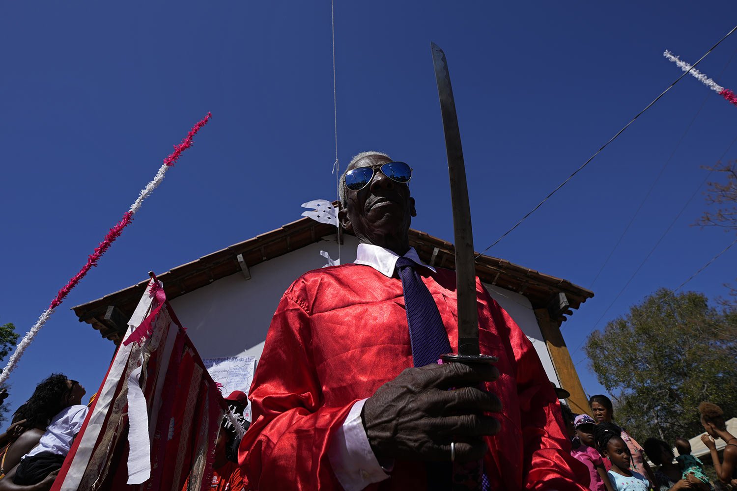  Neco Santana holds a ceremonial sword at the end of a week-long pilgrimage honoring the patron saint in Cavalcante, Goias state, Brazil, Aug. 14, 2022. (AP Photo/Eraldo Peres) 