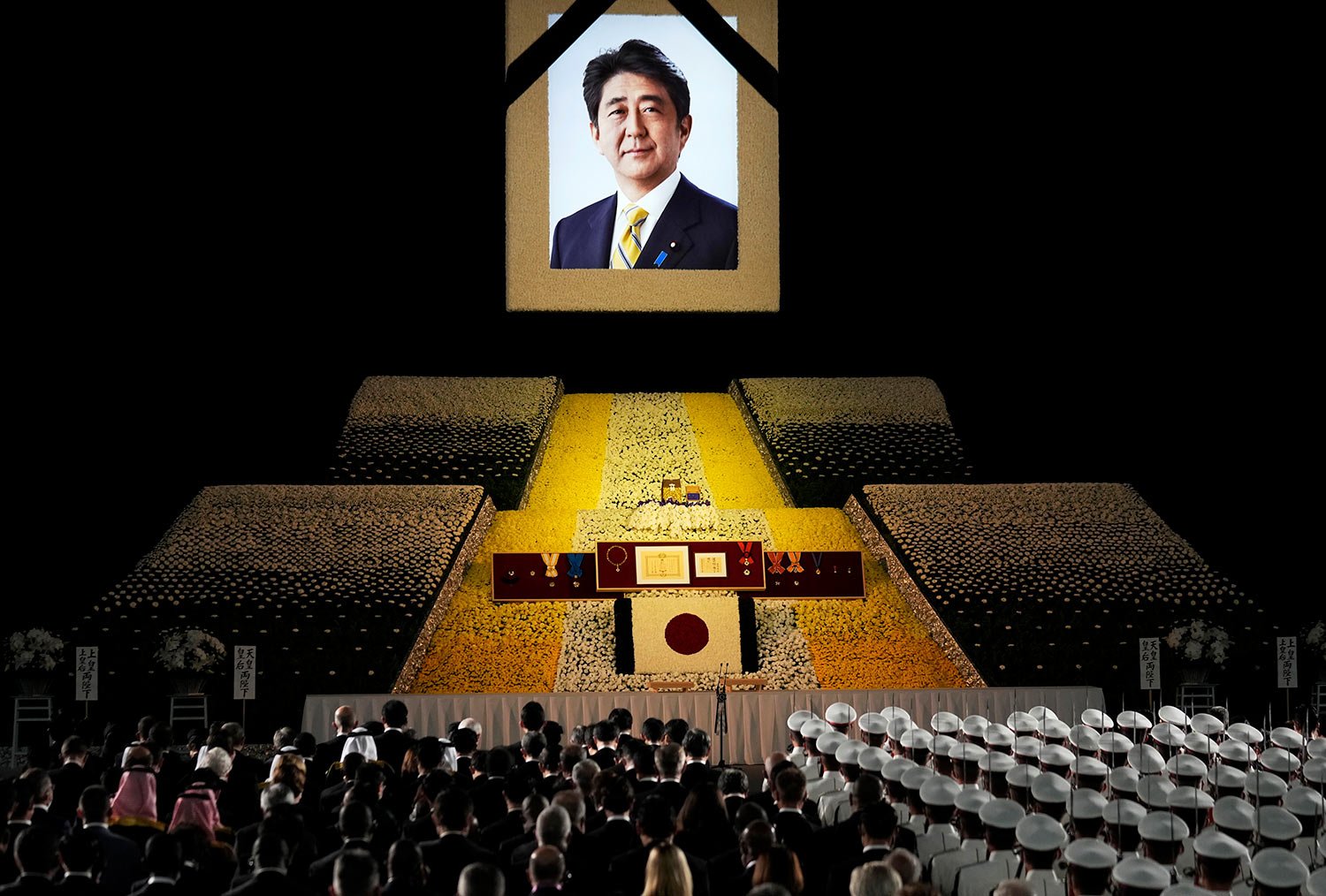  A portrait of former Japanese Prime Minister Shinzo Abe hangs on the stage during his state funeral, Tuesday, Sept. 27, 2022, Tokyo. Abe was assassinated in July. (Franck Robichon/Pool Photo via AP) 