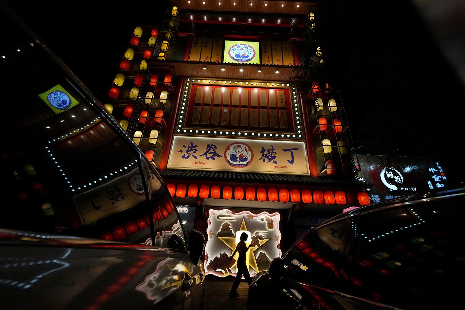  A woman walks past a Japanese restaurant in Beijing, Sunday, Sept. 11, 2022. (AP Photo/Ng Han Guan) 