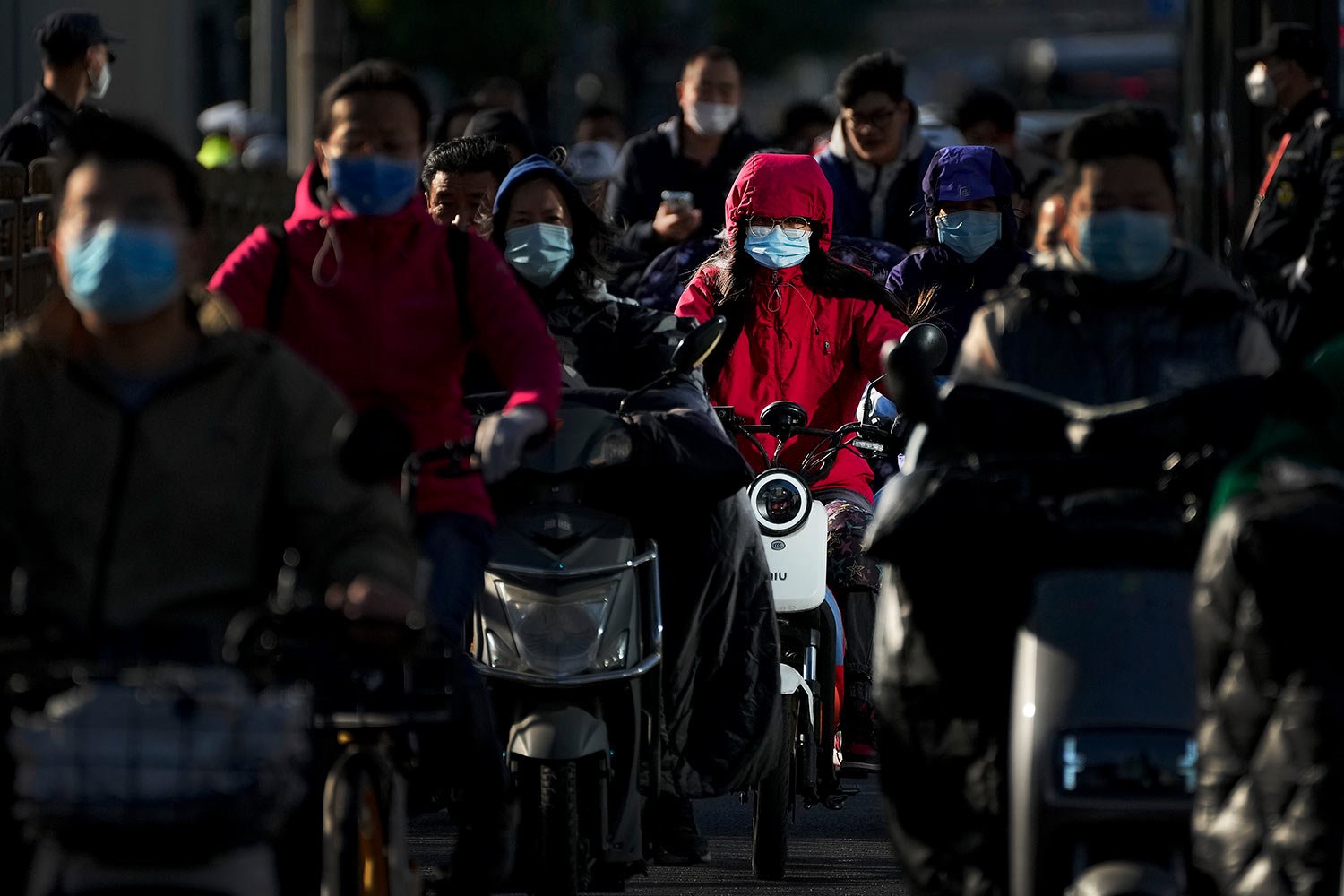 Motorists ride their electric-powered scooters on a street during the opening ceremony of the 20th National Congress of China's ruling Communist Party in Beijing, Sunday, Oct. 16, 2022. (AP Photo/Andy Wong) 