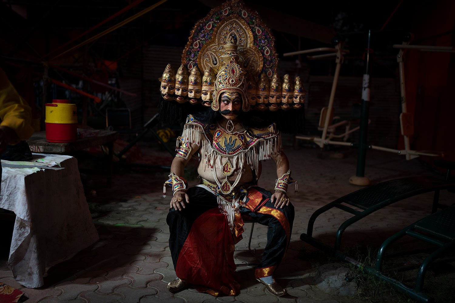  An artist dressed as demon king Ravana sits backstage before the final performance during a traditional Ramleela drama to celebrate the festival of Dussehra in New Delhi, India, Wednesday, Oct. 5, 2022.  (AP Photo/Altaf Qadri) 
