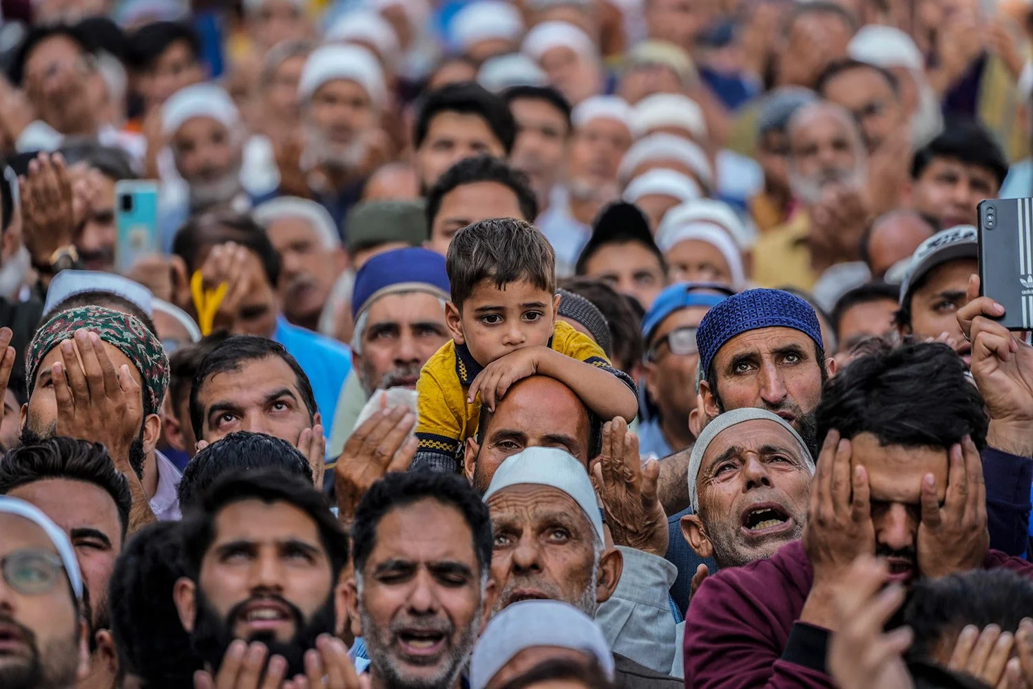Kashmiri Muslims offer prayers as a devotee carries a child on his shoulders at the Hazratbal shrine on Eid-e-Milad, the birth anniversary of Prophet Muhammad, in Srinagar, Indian controlled Kashmir, Sunday, Oct. 9, 2022. (AP Photo/ Mukhtar Khan)