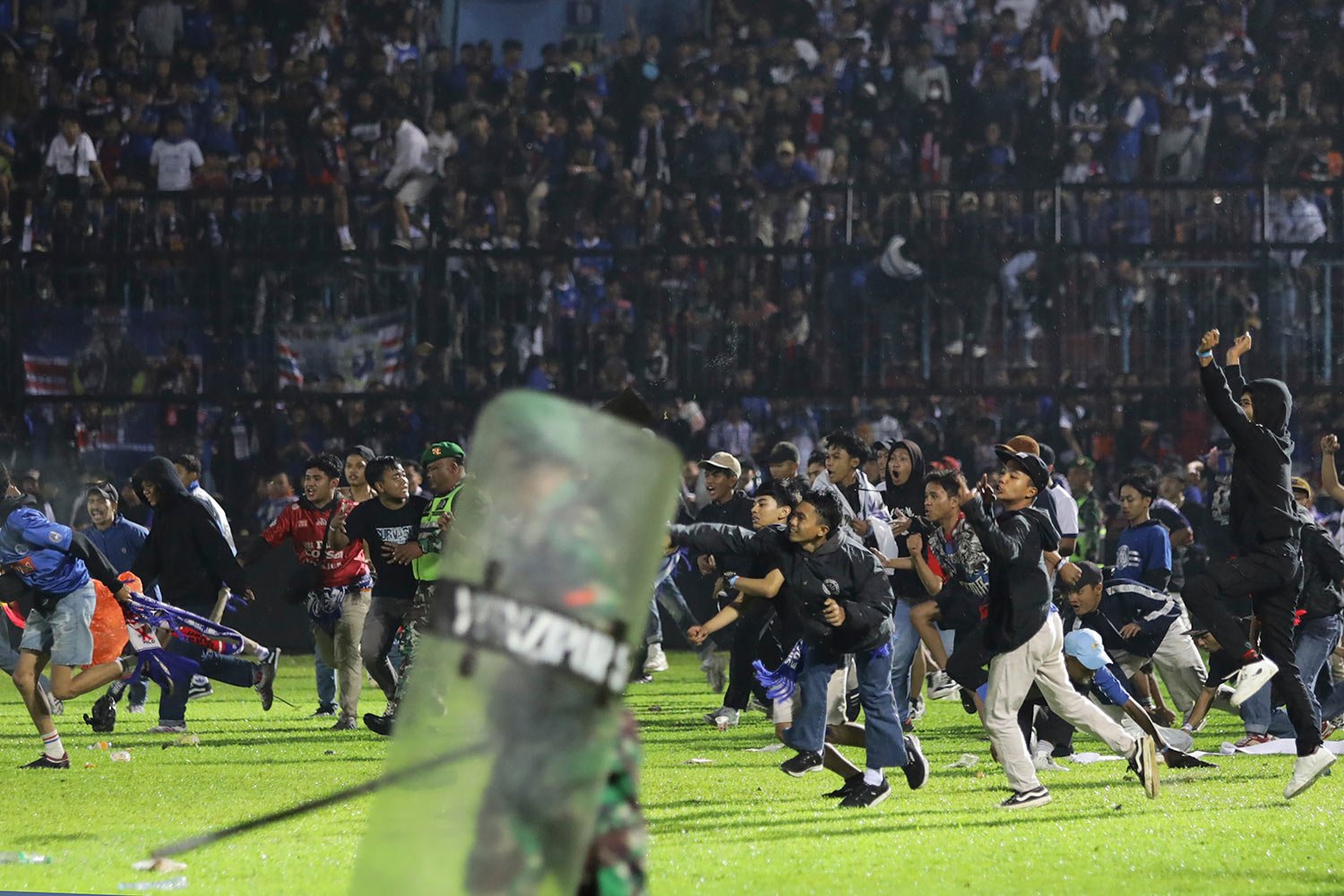  Soccer fans enter the pitch during a clash between supporters at Kanjuruhan Stadium in Malang, East Java, Indonesia, Saturday, Oct. 1, 2022.  (AP Photo/Yudha Prabowo) 