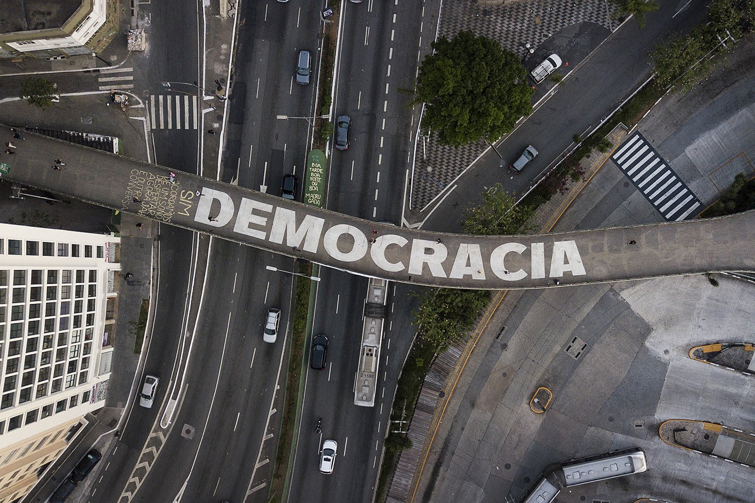  People walk on a pedestrian bridge emblazoned with the Portuguese word for democracy, in Sao Paulo, Brazil, Wednesday, Oct. 26, 2022.  (AP Photo/Matias Delacroix) 
