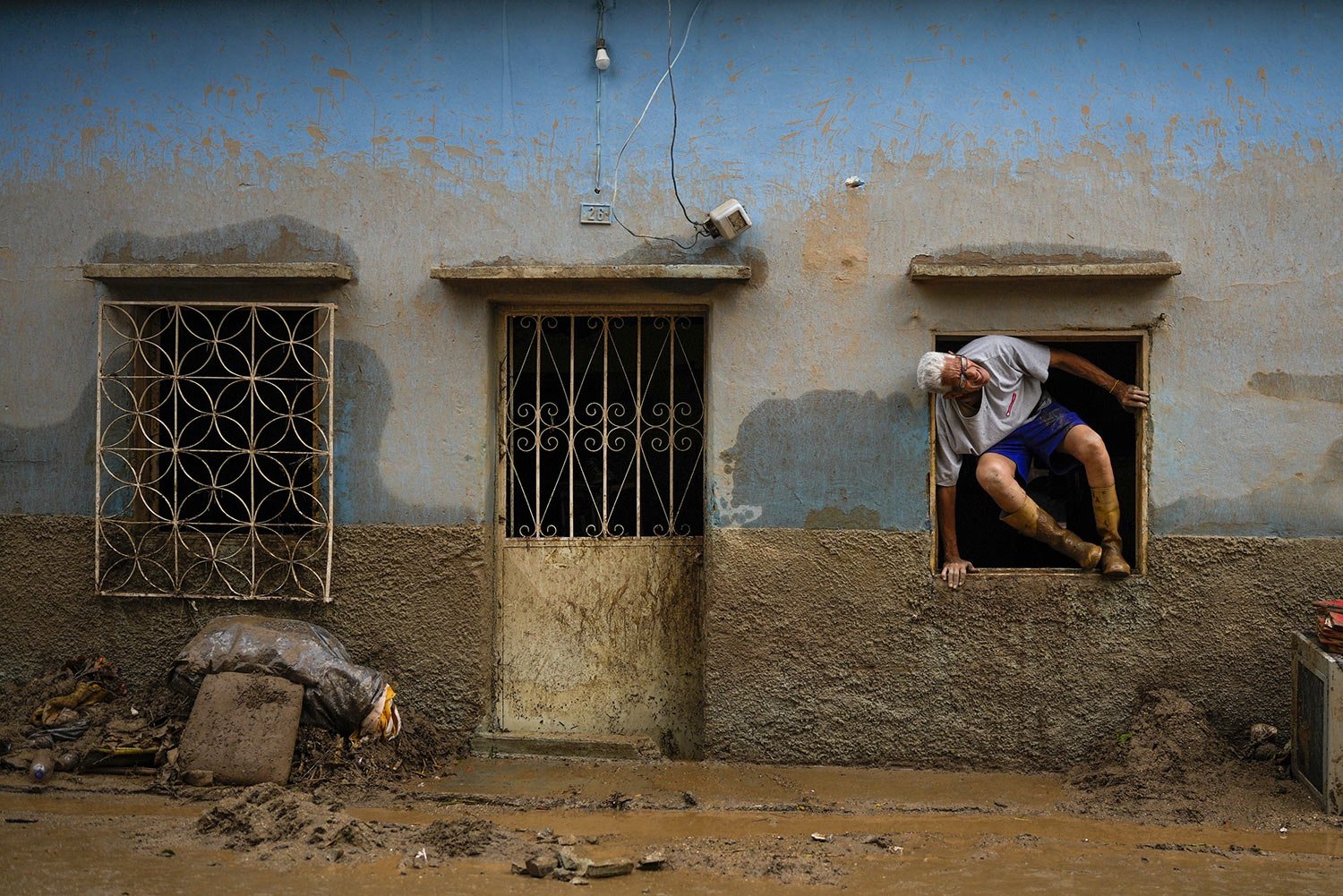  Jose Medina jumps out his home flooded by the overflow of a ravine caused by intense rains in Las Tejerias, Venezuela, Sunday, Oct. 9, 2022. (AP Photo/Matias Delacroix) 