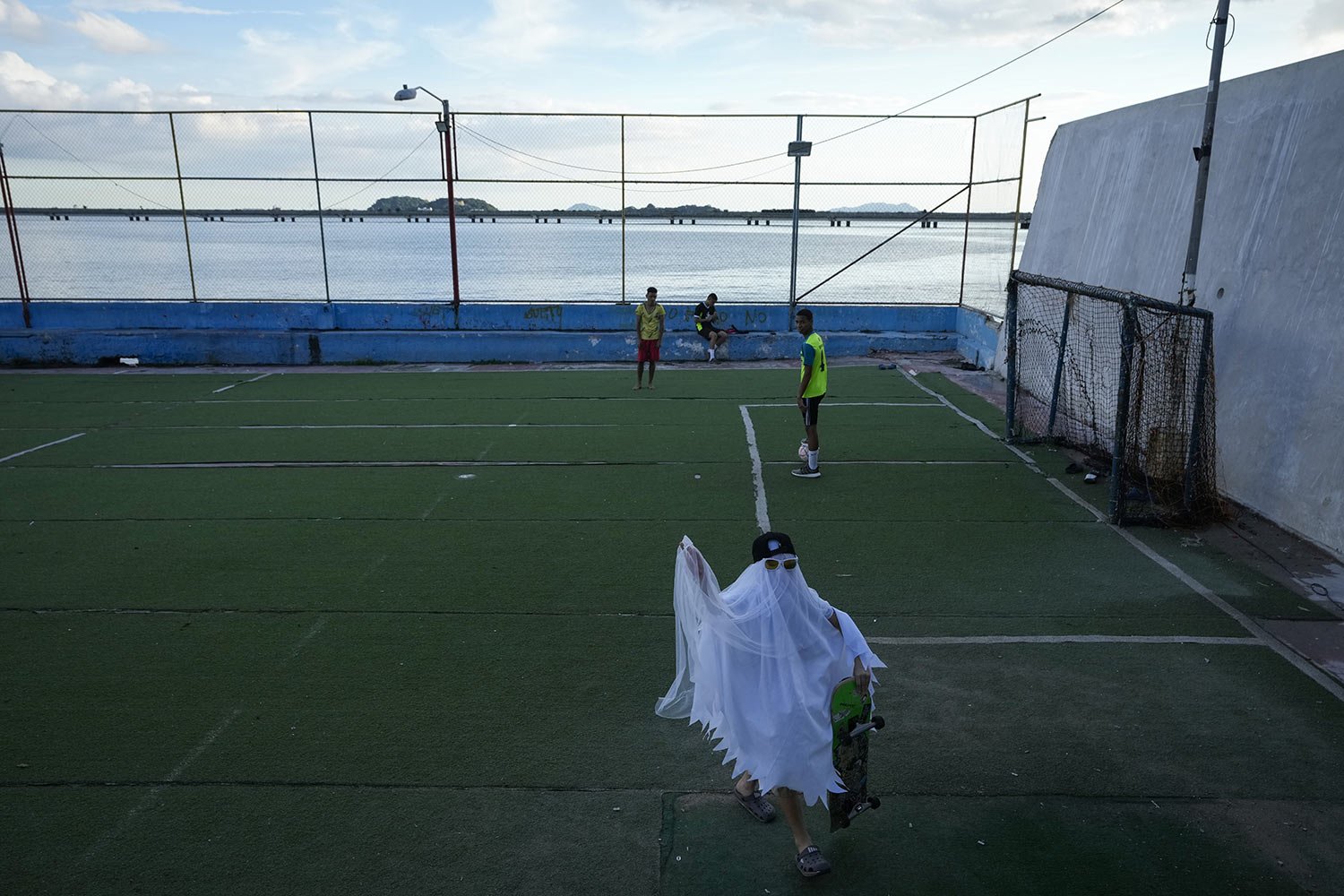  A boy wearing a ghost costume walks past soccer players while trick-or-treating in Panama City, Friday, Oct. 28, 2022. (AP Photo/Arnulfo Franco) 