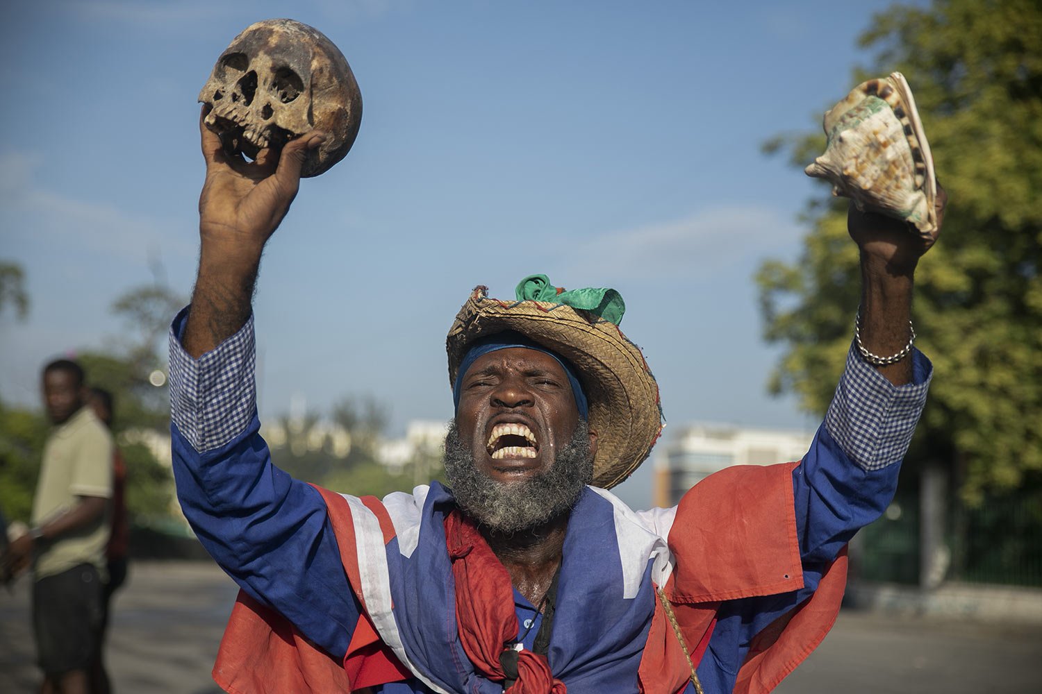  A protester holding up a skull and seashell shouts for the resignation of Haitian Prime Minister Ariel Henry in the street in the Champs de Mars area where the prime minister attended a ceremony marking the death anniversary of revolutionary leader 