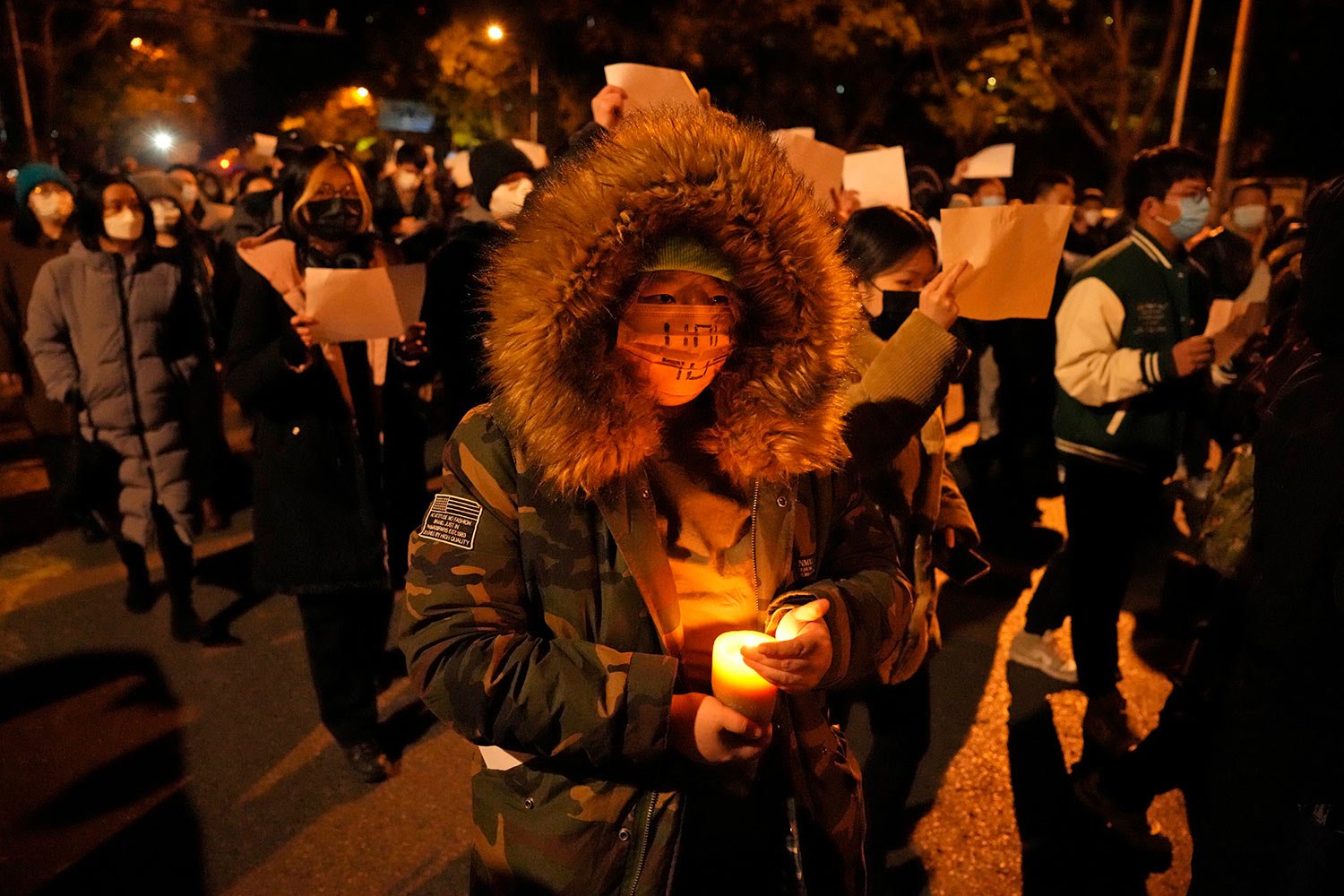  Protesters hold up blank papers and chant slogans as they march in protest in Beijing, Sunday, Nov. 27, 2022. (AP Photo/Ng Han Guan) 