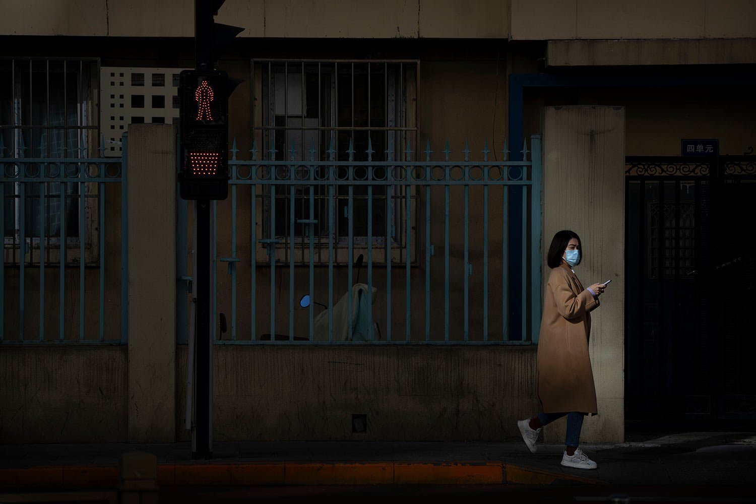  A woman wearing a face mask walks along a street in Beijing, Friday, Nov. 4, 2022.  (AP Photo/Mark Schiefelbein) 