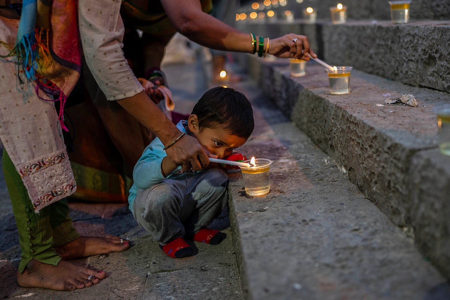 A Hindu boy lights an oil lamp at the Banganga pond as they celebrate Dev Diwali festival in Mumbai, India, Monday, Nov. 7, 2022. (AP Photo/Rafiq Maqbool) 