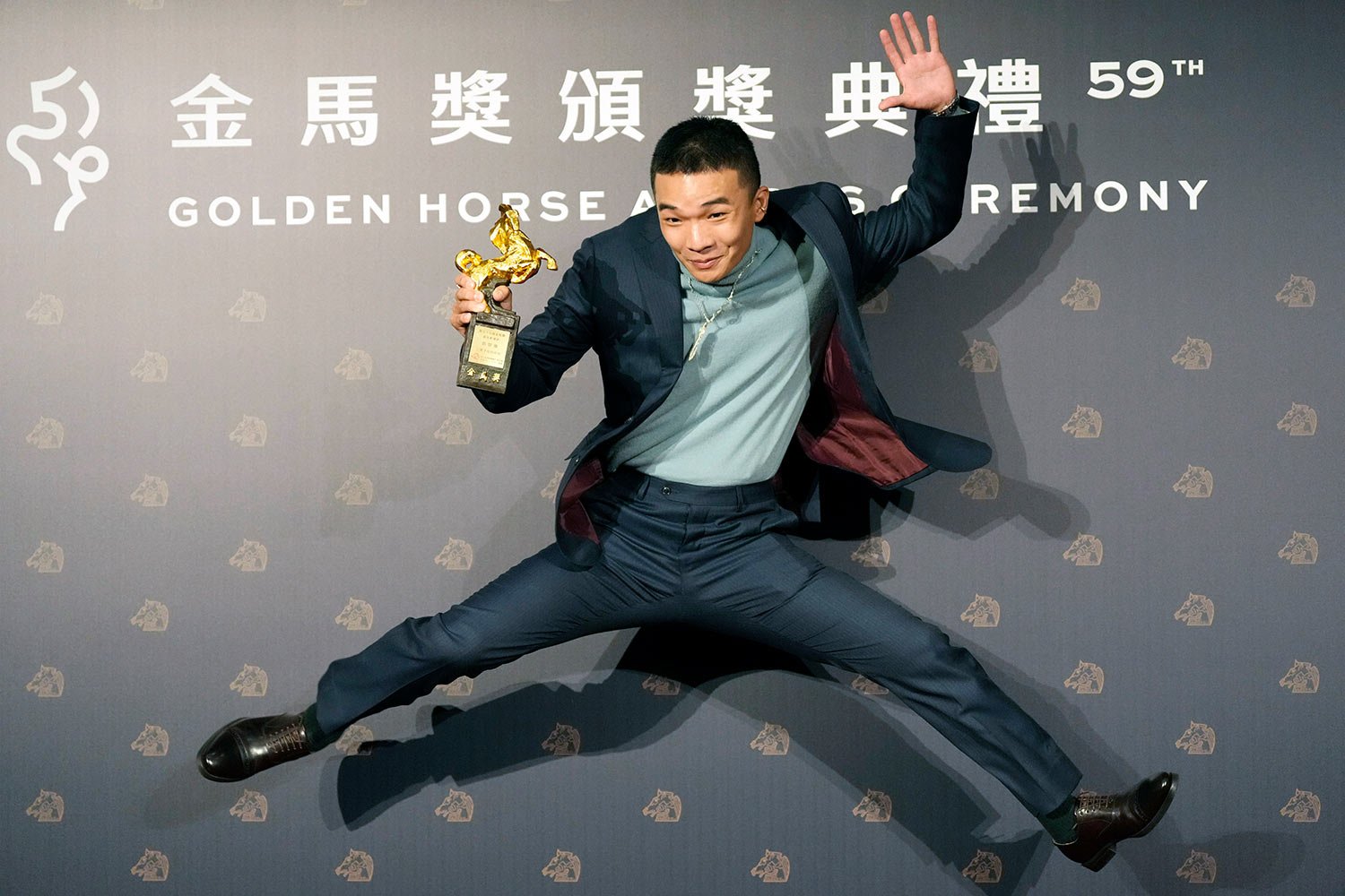  Taiwanese actor Hu Jhih-ciang jumps with his award for Best New Performer at the 59th Golden Horse Awards in Taipei, Taiwan, Saturday, Nov. 19, 2022.  (AP Photo/Billy Dai) 