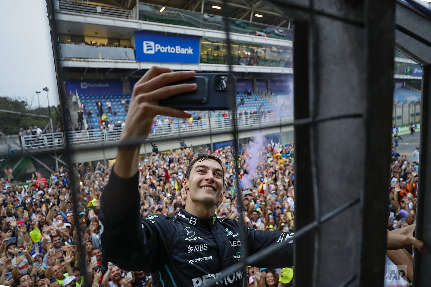  Mercedes driver George Russell, of Britain, takes a selfie with the crowd in the background after winning the Brazilian Formula One Grand Prix at the Interlagos race track in Sao Paulo, Brazil, Sunday, Nov. 13, 2022. (AP Photo/Marcelo Chello) 