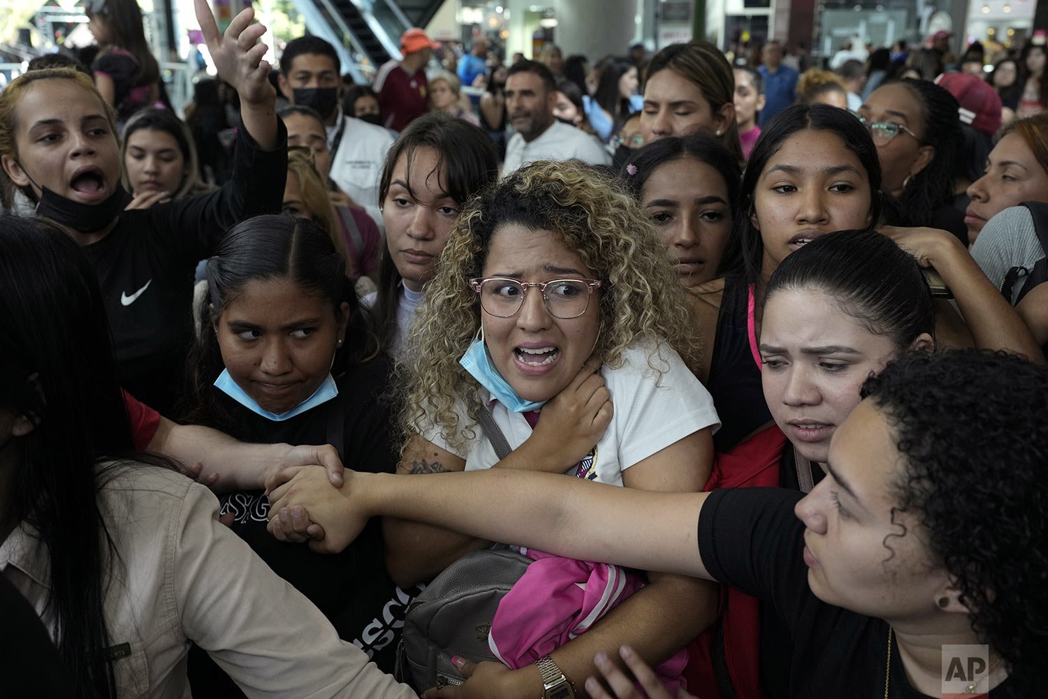 Employees force Black Friday shoppers to create an orderly line before entering a shoe store, in groups of 10 for a limited time of 10 minutes, at the Sambil Mall in Caracas, Venezuela, Friday, Nov. 26, 2022. (AP Photo/Ariana Cubillos) 