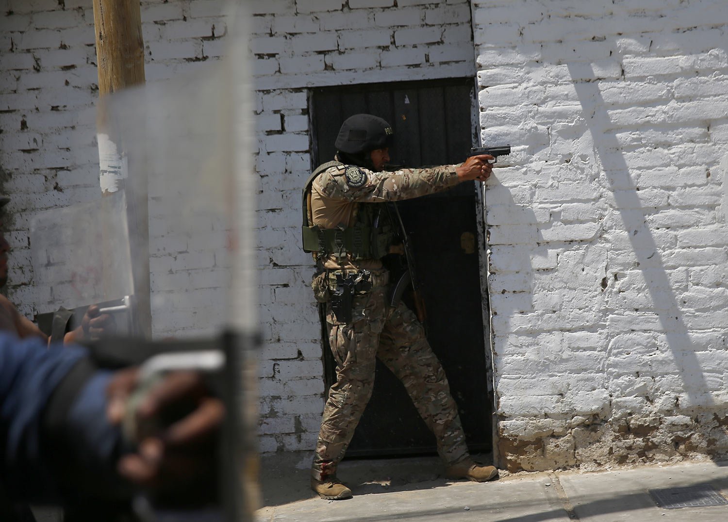  A police officer aims his weapon at supporters of ousted Peruvian President Pedro Castillo, during a protest against his detention, in Chao, Peru, Thursday, Dec. 15, 2022. (AP Photo/Hugo Curotto) 