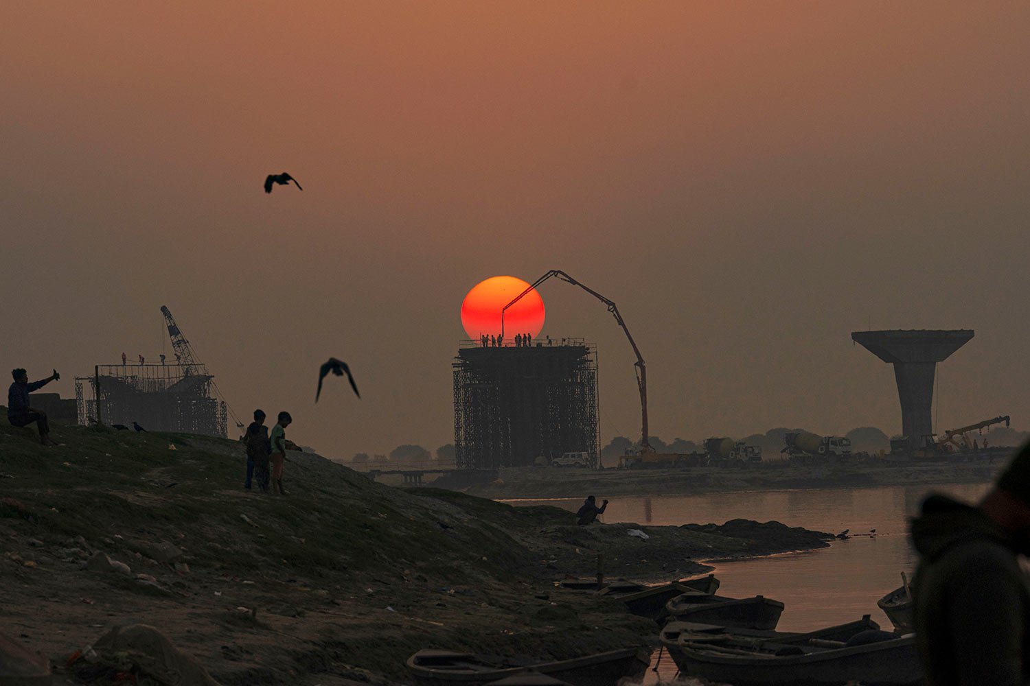  Laborers work at a construction site on the banks of river Ganges as the sun sets in Prayagraj, India, Thursday, Dec. 22, 2022. (AP Photo/Rajesh Kumar Singh) 