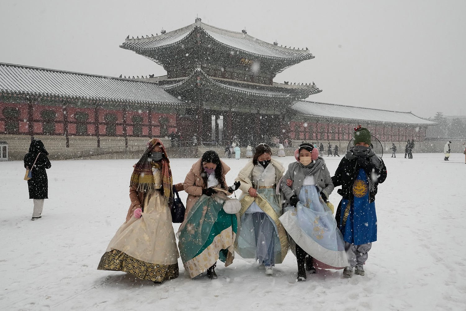  Visitors wearing traditional "Hanbok" costumes walk through the snow at the Gyeongbok Palace, the main royal palace during the Joseon Dynasty, and one of South Korea's well known landmarks in Seoul, South Korea. Thursday, Dec. 15, 2022. (AP Photo/Ah