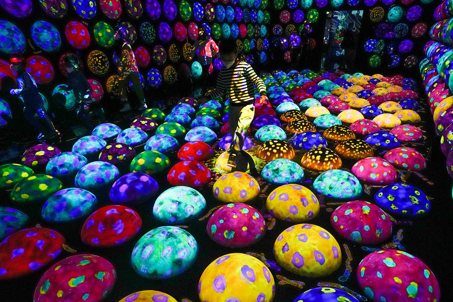  Children play on a digital art installation titled "Rapidly Rotating Bouncing Spheres in the Caterpillar House", at the newly-opened "teamLab Massless" museum in Beijing, Monday, Dec. 26, 2022.  (AP Photo/Andy Wong) 