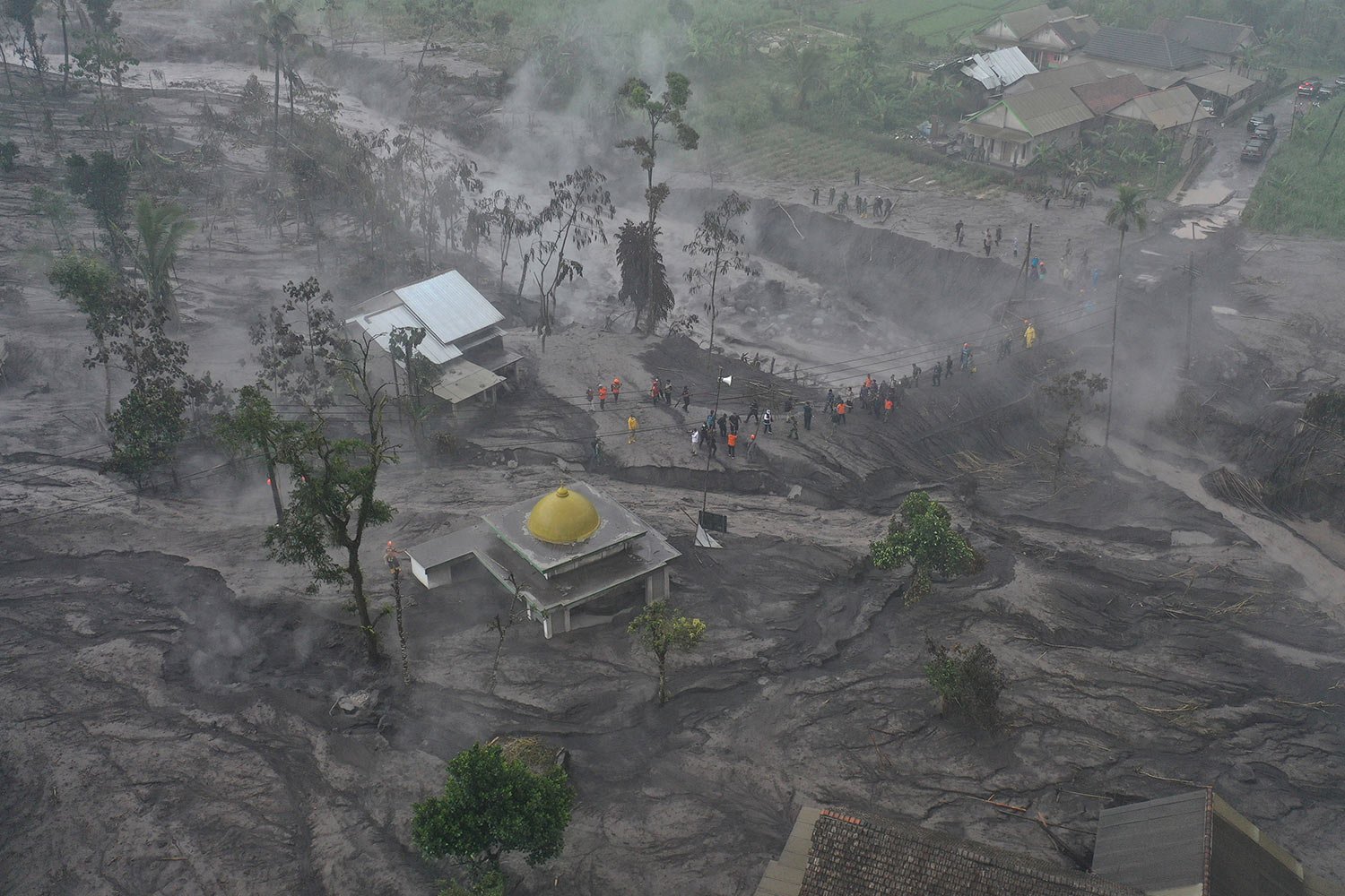  In this aerial photo taken with a drone rescuers inspect the damage at a village affected by the eruption of Mount Semeru in Sumberwuluh, Lumajang, East Java, Indonesia, Monday, Dec. 5, 2022.  (AP Photo/Trisnadi) 