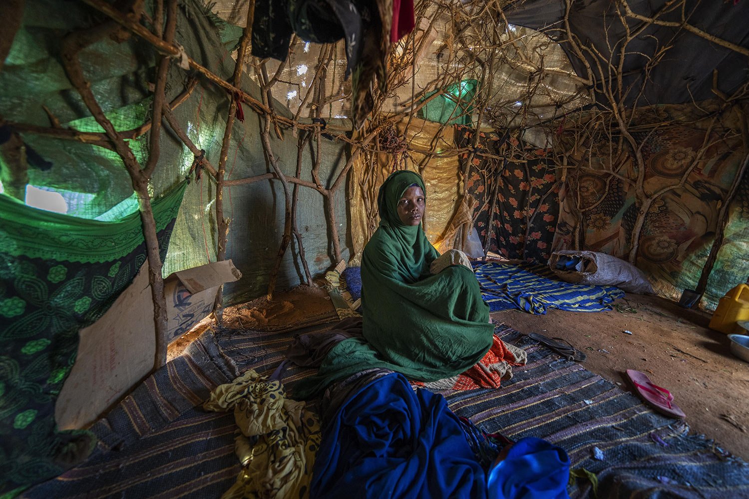  Fartum Issack sits in a shelter at a camp for displaced people on the outskirts of Dollow, Somalia, Sept. 19, 2022. Issack and her husband carried a small body along a dusty track to a graveyard. Their 1-year-old daughter had arrived at camp sick an