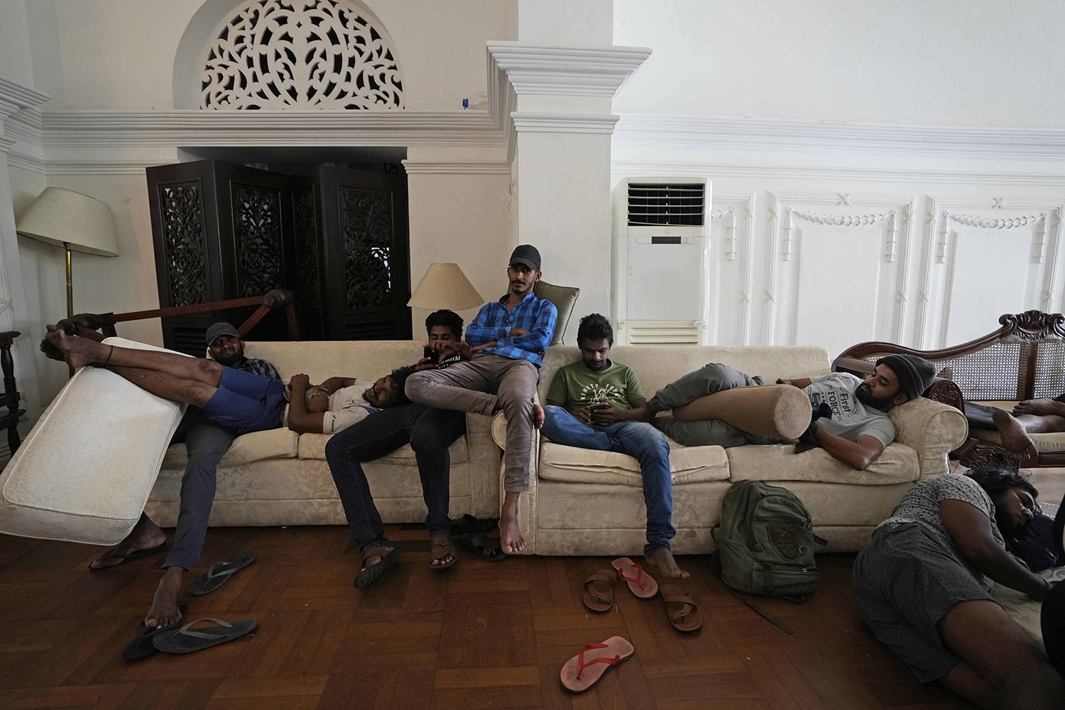  Protesters sit in the living room of the prime minister's residence a day after storming it, in Colombo, Sri Lanka, July 10, 2022. (AP Photo/Eranga Jayawardena) 