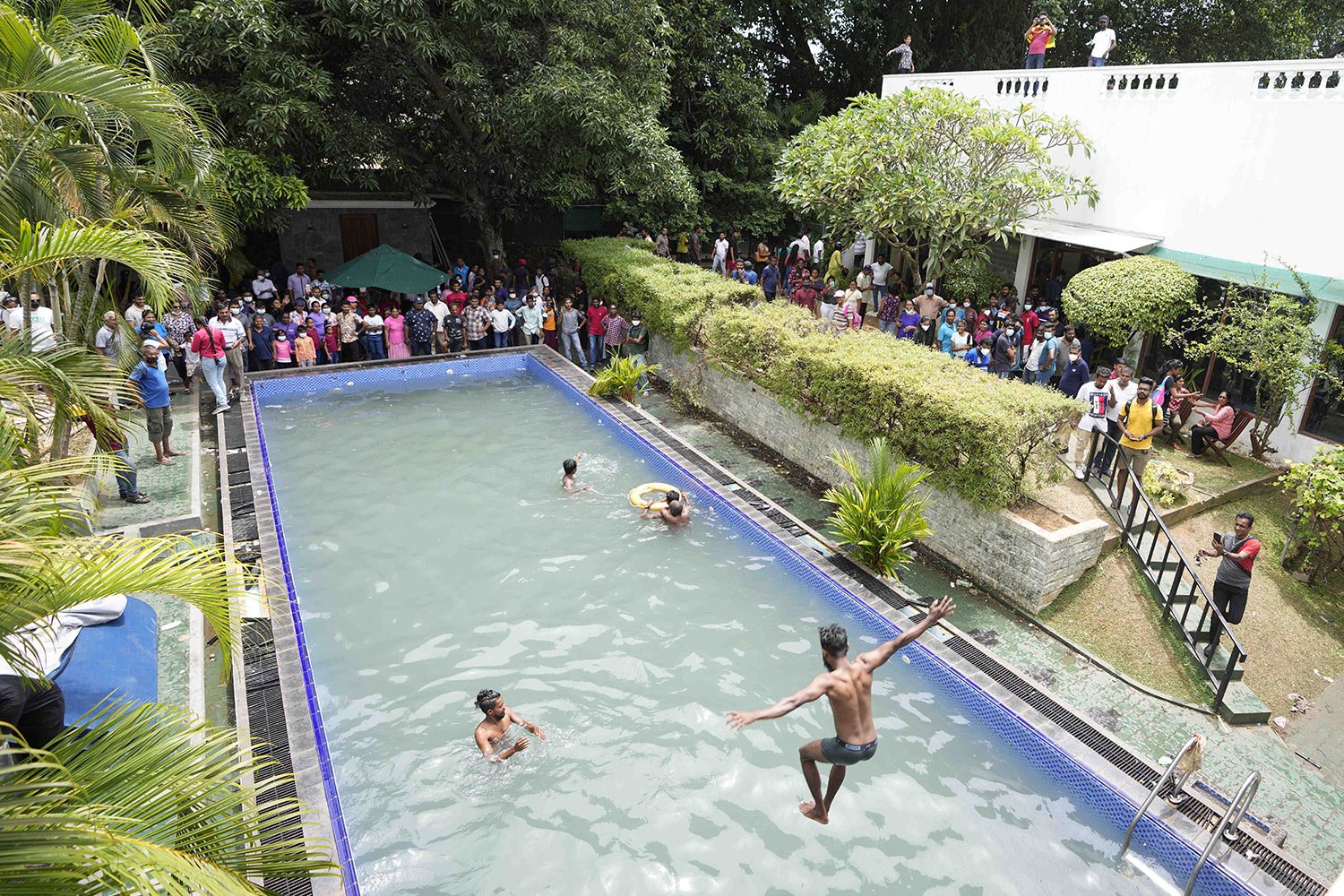  Protesters swim in a pool at the presidential residence a day after it was stormed, in Colombo, Sri Lanka, July 10, 2022. (AP Photo/Eranga Jayawardena) 