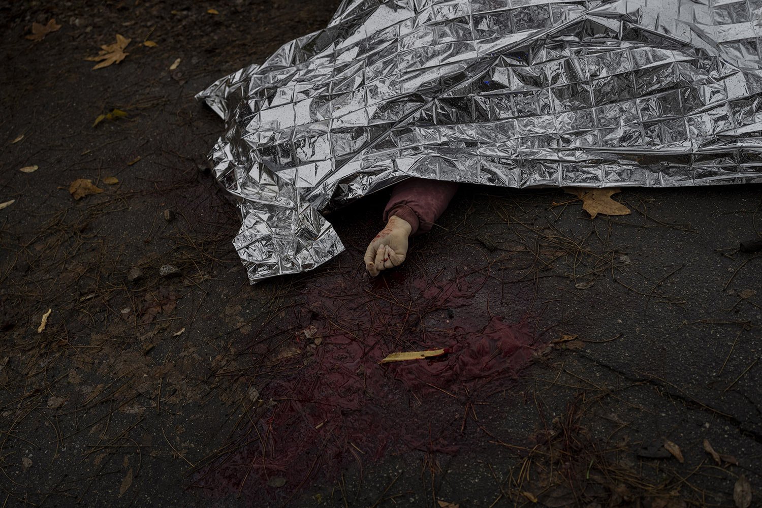  The body of a woman killed during a Russian attack is covered with an emergency blanket before being transported to the morgue in Kherson, southern Ukraine, Nov. 25, 2022. (AP Photo/Bernat Armangue) 