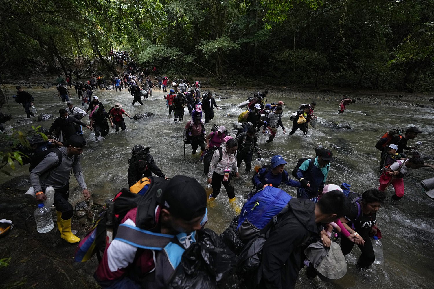  Migrants, mostly Venezuelans, cross a river during their journey through the Darien Gap from Colombia into Panama, Oct. 15, 2022. (AP Photo/Fernando Vergara) 