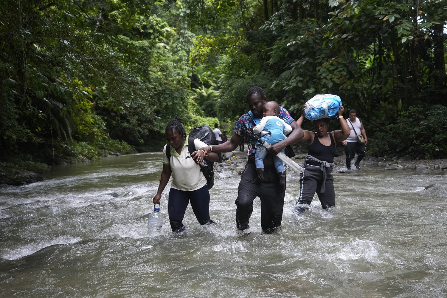  Haitian migrants wade through a river as they cross the Darien Gap, from Colombia into Panama, Oct. 15, 2022. (AP Photo/Fernando Vergara) 