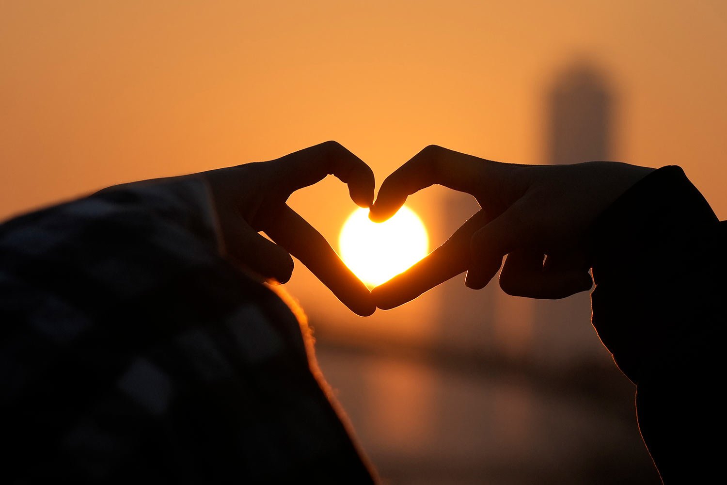  People form the shape of a heart as they pose for photo with the first sunrise on New Year's Day at a park in Seoul, South Korea, Sunday, Jan. 1, 2023. (AP Photo/Lee Jin-man) 