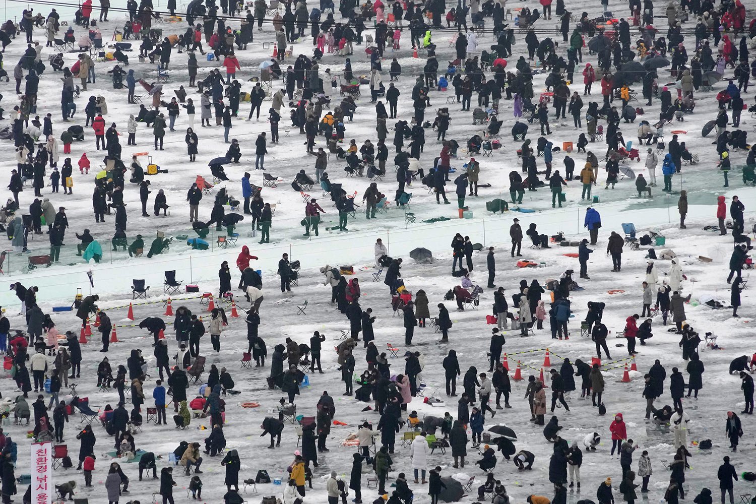  Participants cast lines through holes drilled in the surface of a frozen river during a trout-catching contest in Hwacheon, South Korea, Saturday, Jan. 7, 2023. (AP Photo/Ahn Young-joon) 