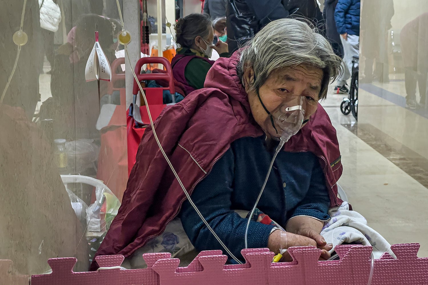  An elderly patient receives an intravenous drip while using a ventilator in the hallway of the emergency ward in Beijing, Thursday, Jan. 5, 2023. (AP Photo/Andy Wong) 