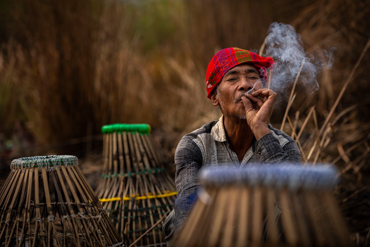  A Karbi tribal man smokes as he joins a community fishing event as part of Bhogali Bihu celebrations in Panbari village, some 50 kilometers (31 miles) east of Guwahati, India, Saturday, Jan. 14, 2023. (AP Photo/Anupam Nath) 