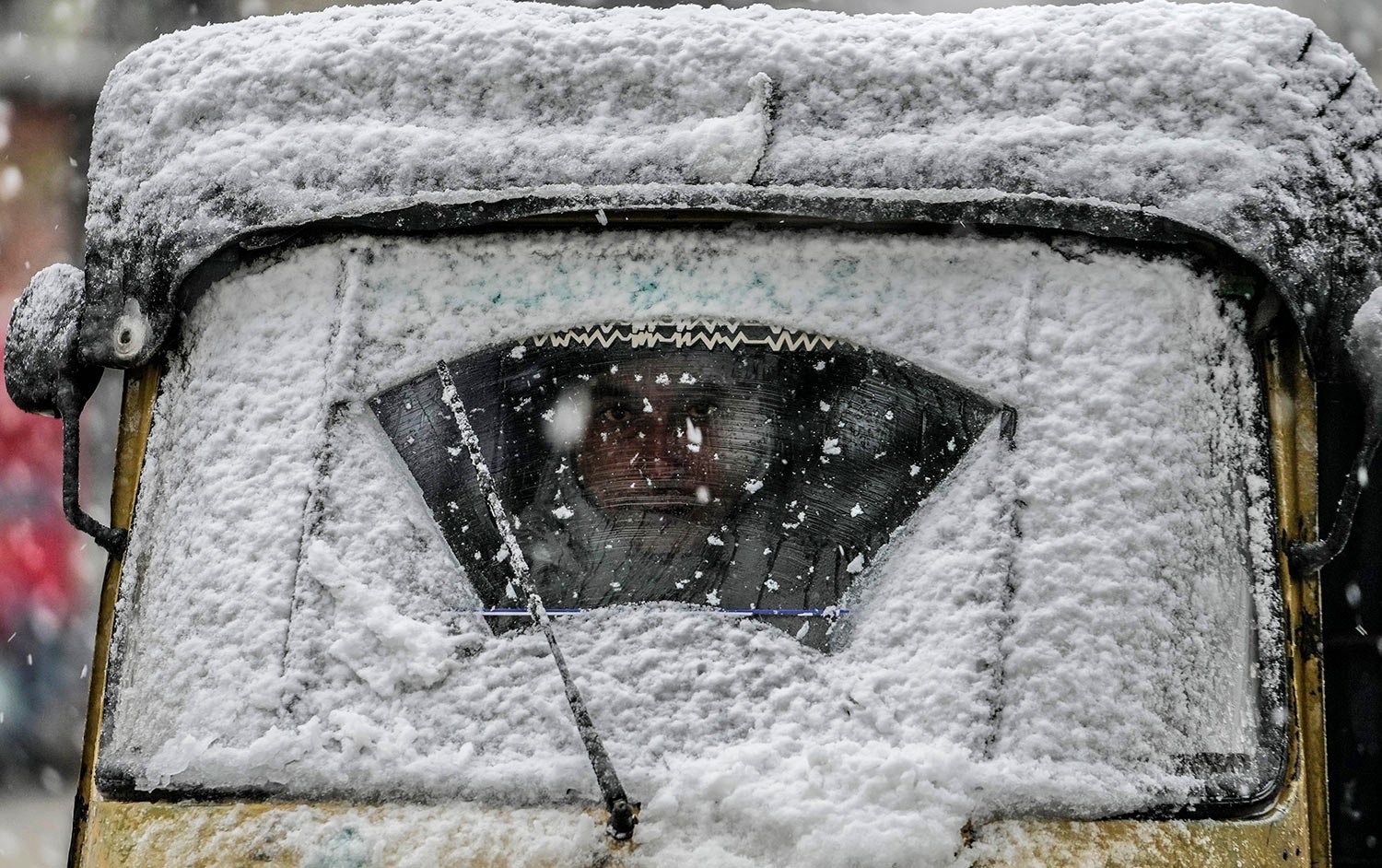  An auto driver looks through a snow-covered windshield in Srinagar, Indian controlled Kashmir, Friday, Jan. 13, 2023. (AP Photo/Mukhtar Khan) 