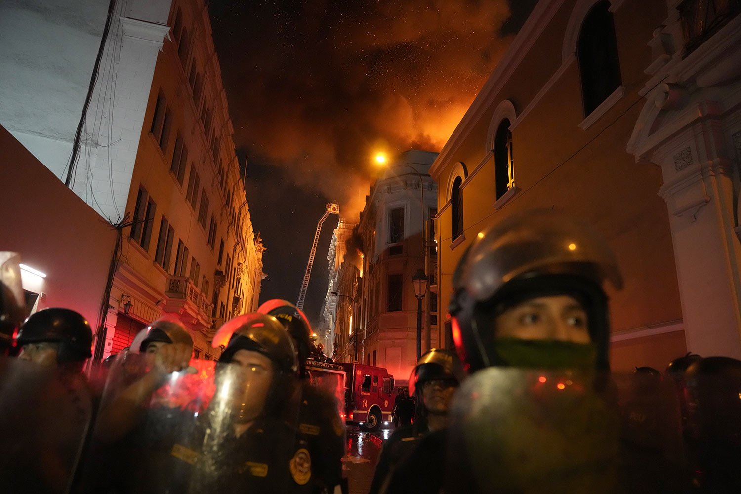  Police block a street as a building burns behind during clashes with anti-government protesters in Lima, Peru, Jan. 19, 2023. Protesters are seeking immediate elections, President Dima Boluarte's resignation, the release of ousted President Pedro Ca