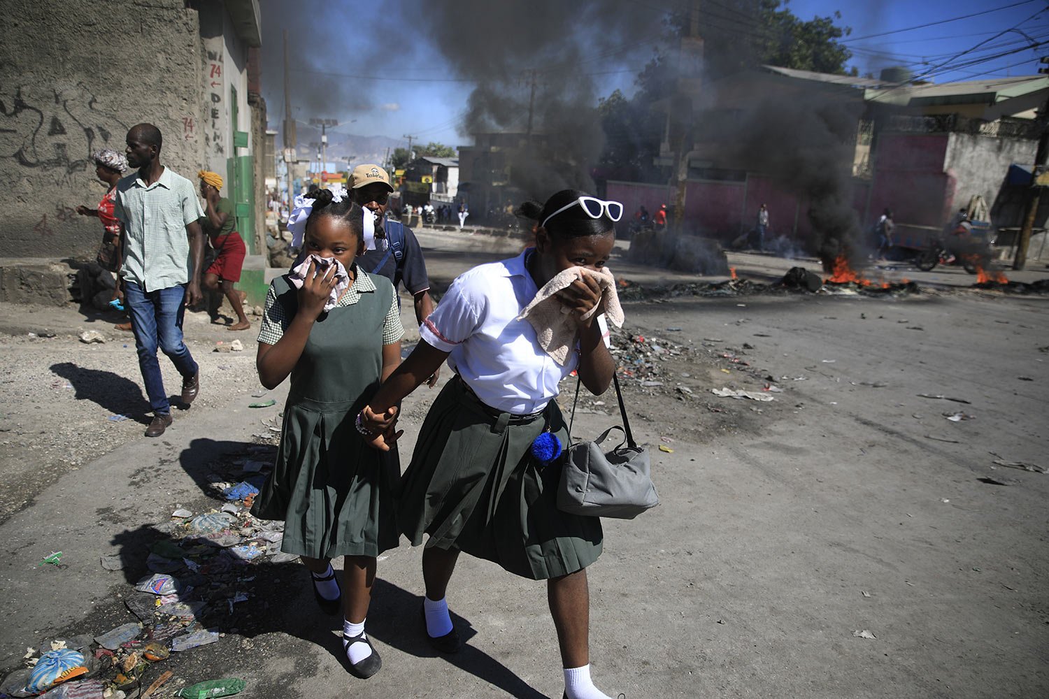  Students walk past a burning roadblock that was set up by  police protesting bad police governance in Port-au-Prince, Haiti, Jan. 26, 2023. (AP Photo/Odelyn Joseph) 