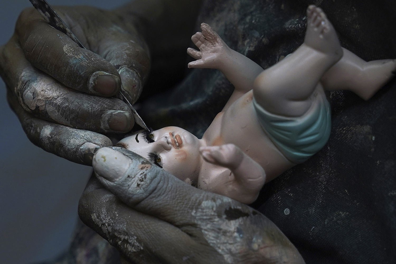  A man repairs a Baby Jesus figure in Mexico City, Jan. 25, 2023. As Mexicans prepare to celebrate Candlemas, people bring in their statues for major repairs. (AP Photo/Marco Ugarte) 