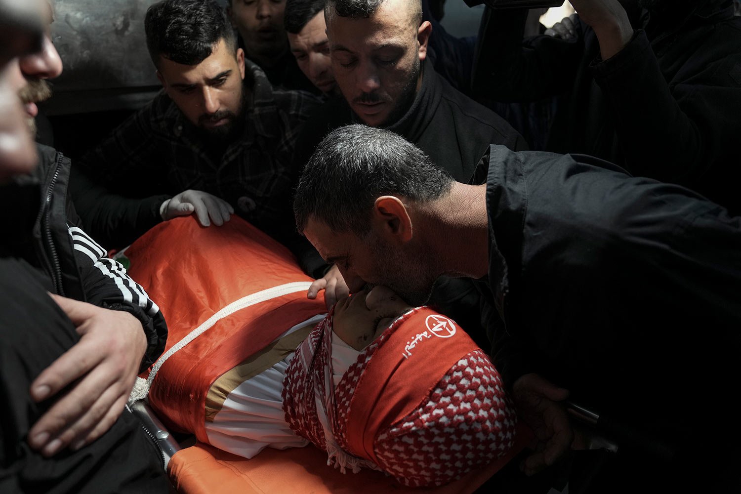  Mourners gather around the body of 14-year-old Palestinian Omar Khumour during his funeral in the West Bank city of Bethlehem, Monday, Jan. 16, 2023. (AP Photo/Mahmoud Illean) 