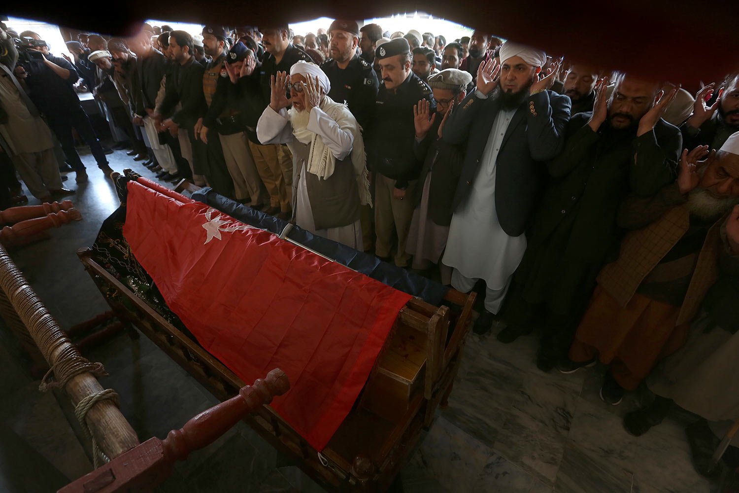  People attend the funeral prayer for a police officer killed in Monday's suicide bombing inside a mosque in Peshawar, Pakistan, Tuesday, Jan. 31, 2023. (AP Photo/Muhammad Sajjad) 